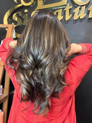 Long layered hair with honey blonde highlights and bouncy curls